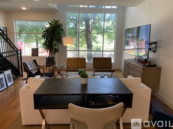 A modern dining room with a black table and white chairs.