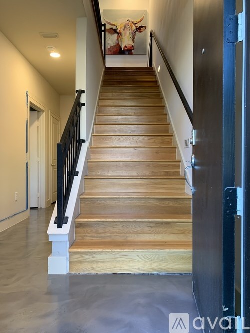 A staircase with wooden steps and a black railing.