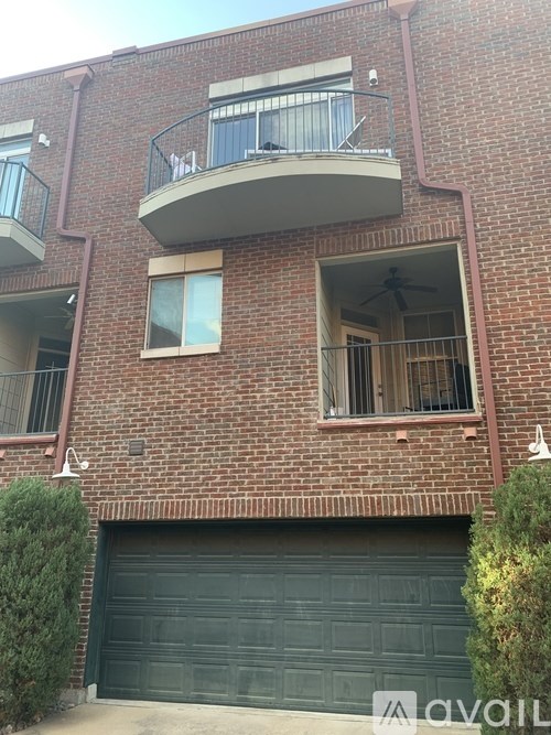 A red brick building with a balcony and a garage door.