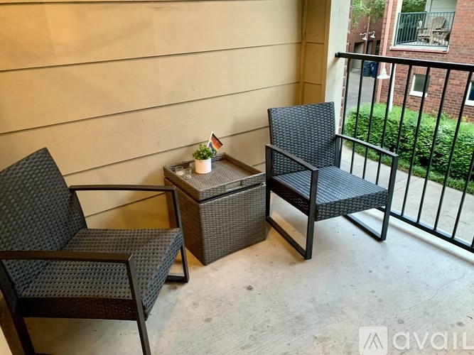 Two chairs and a table on a balcony.