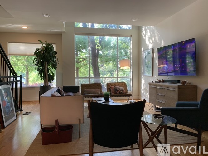 A living room with a couch, chairs, and a television.