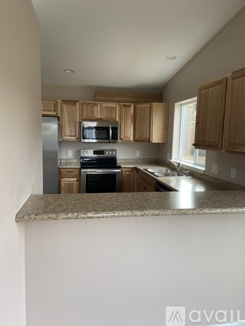 A kitchen with wooden cabinets and granite countertops.