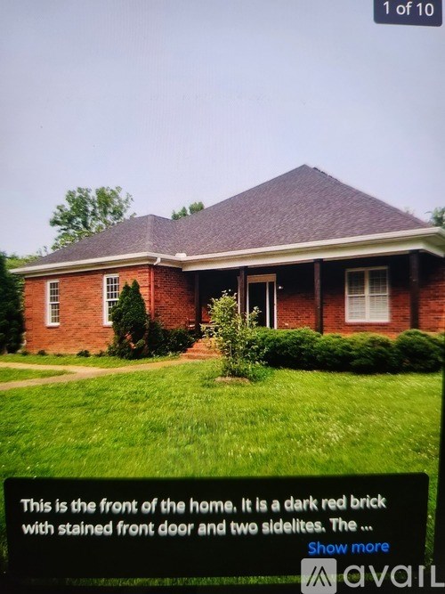 A dark red brick house with a stained front door and two sidelites.