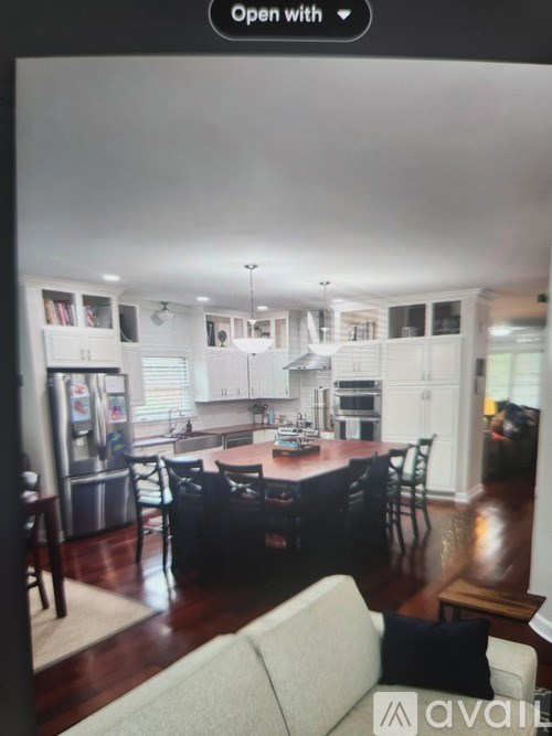 A modern kitchen with white cabinets and a dining area with a table and chairs.