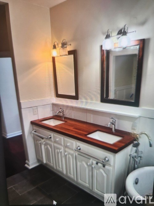 A bathroom with a wooden vanity and a white toilet.