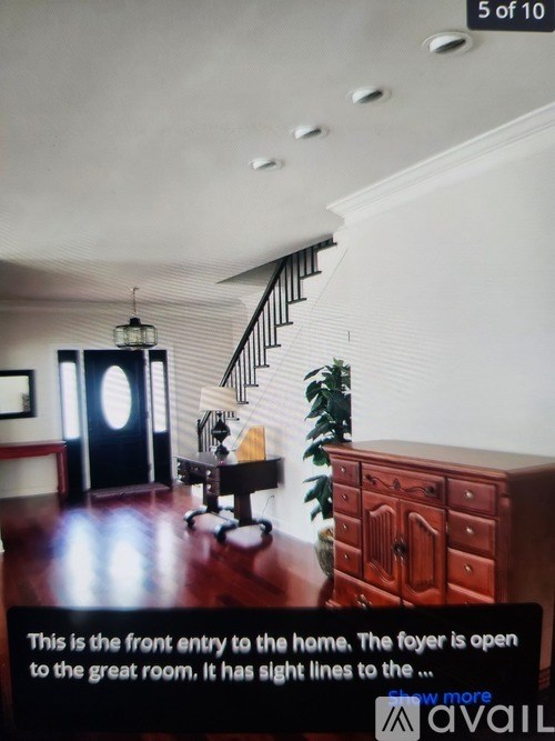 A foyer with a staircase and a plant.