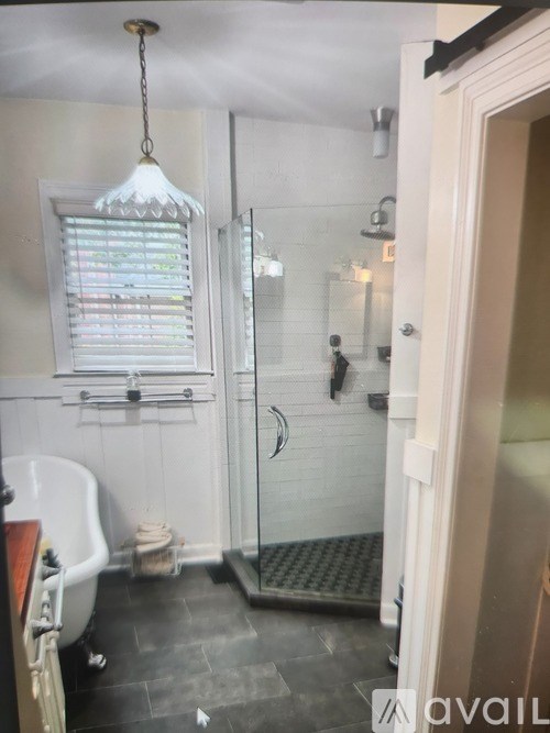A bathroom with a white tub and a glass shower stall.