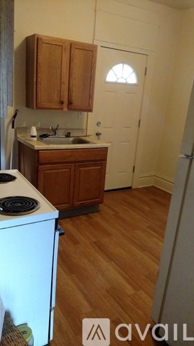 A kitchen with wooden cabinets and a white fridge.