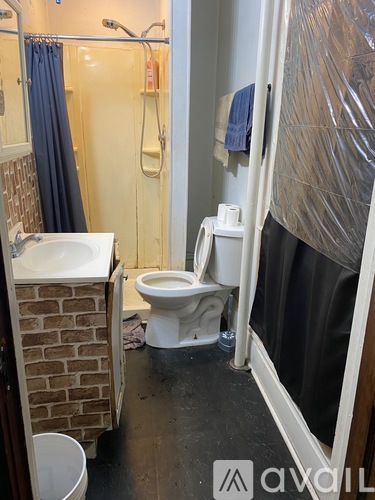 A bathroom with a toilet, sink, and shower.