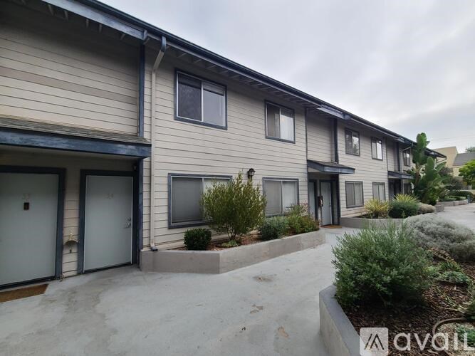A row of houses with the front door of the first one open.