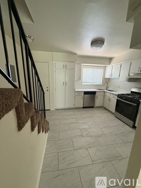 A kitchen with white cabinets and a stove top oven.