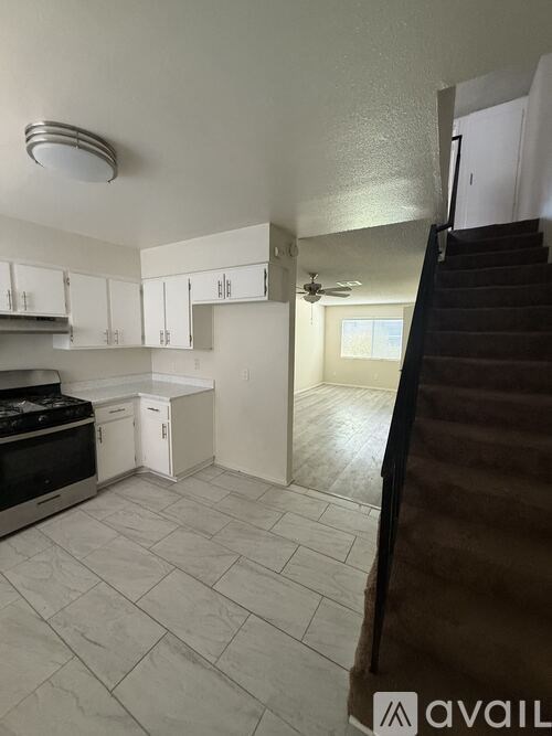 A kitchen with white cabinets and a stove top oven.