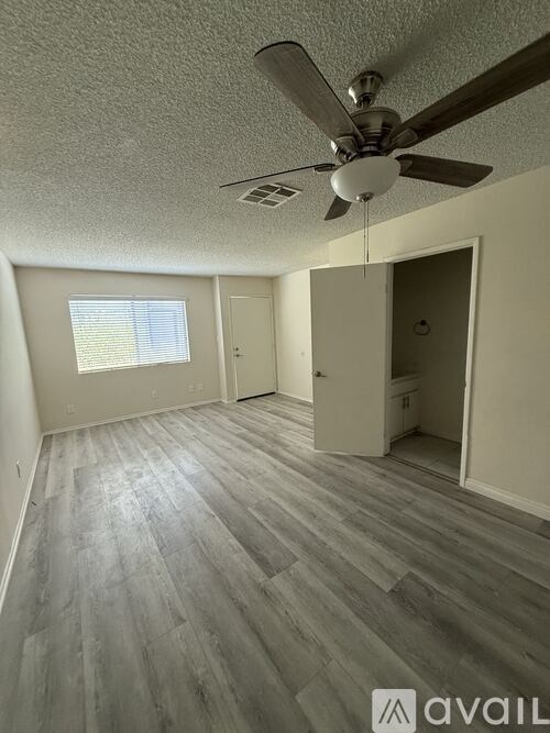 A room with a ceiling fan and a window.