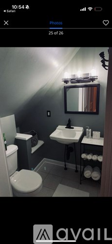 A bathroom with a toilet, sink, and mirror.