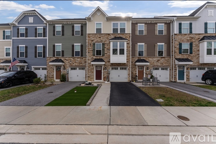 A row of townhouses with a car parked in front of the first one.
