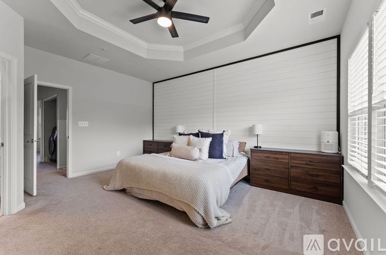 A bedroom with a large bed and a ceiling fan.