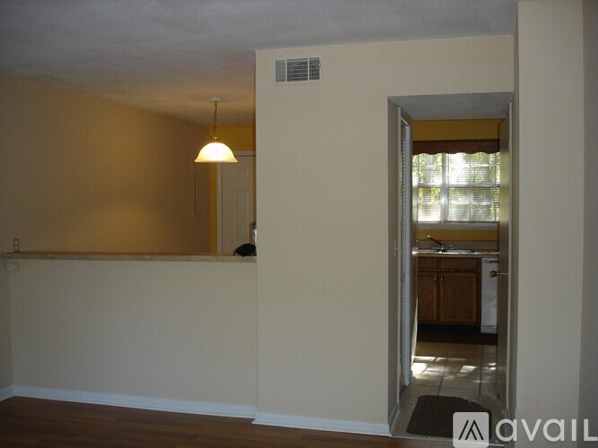 A room with a lamp and a doorway leading to another room.