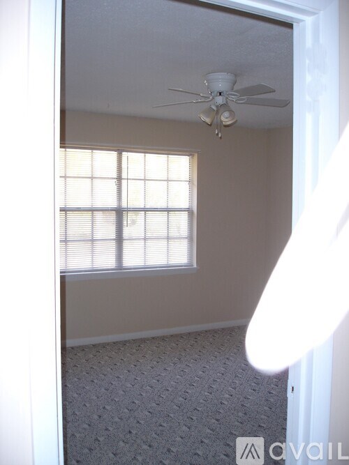 A room with a ceiling fan and a window.