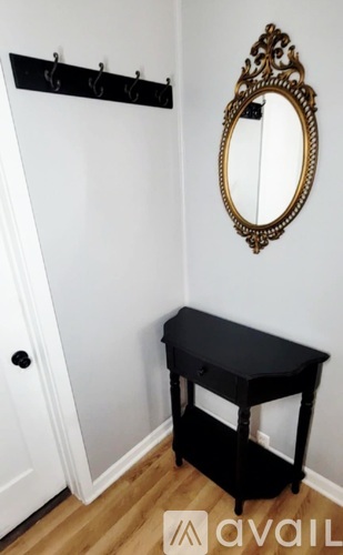 A black table with a mirror above it.