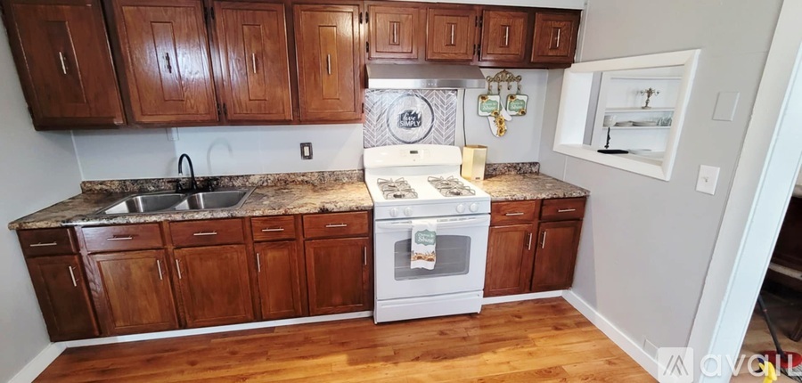 A kitchen with wooden cabinets and a white oven.