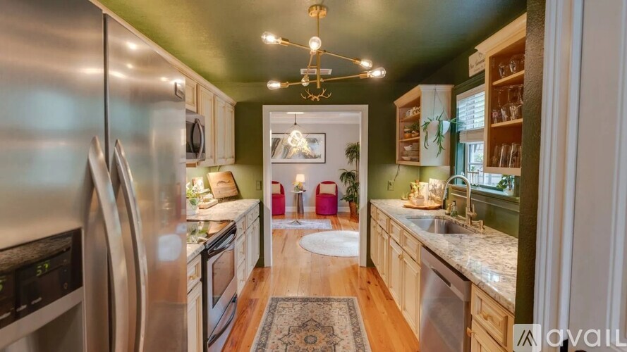 A kitchen with a refrigerator, sink, and a rug on the floor.