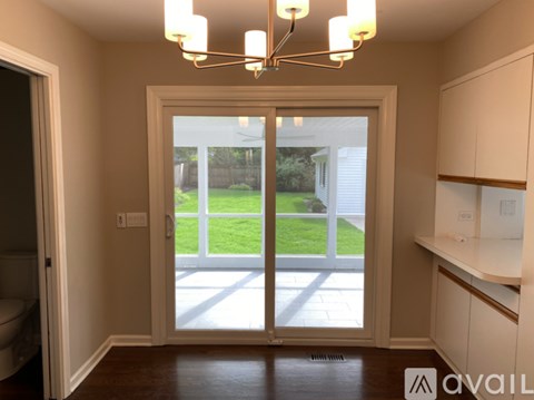 A room with a sliding glass door leading to a backyard.