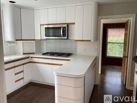 A kitchen with white cabinets and a white counter top.