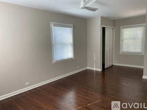 A room with wooden floors and a ceiling fan.