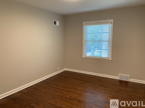 A room with a window and wooden flooring.