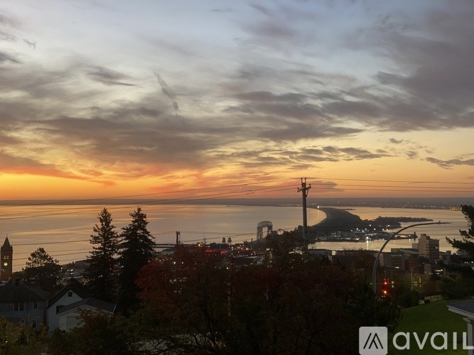 A sunset view of a city with buildings and trees.