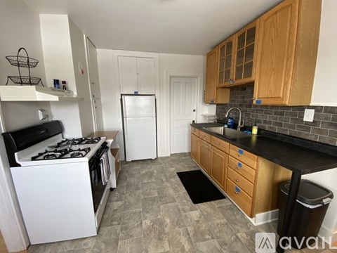 A kitchen with a white stove and wooden cabinets.