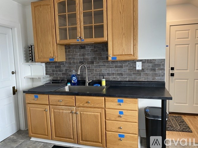 A kitchen with wooden cabinets and a black countertop.
