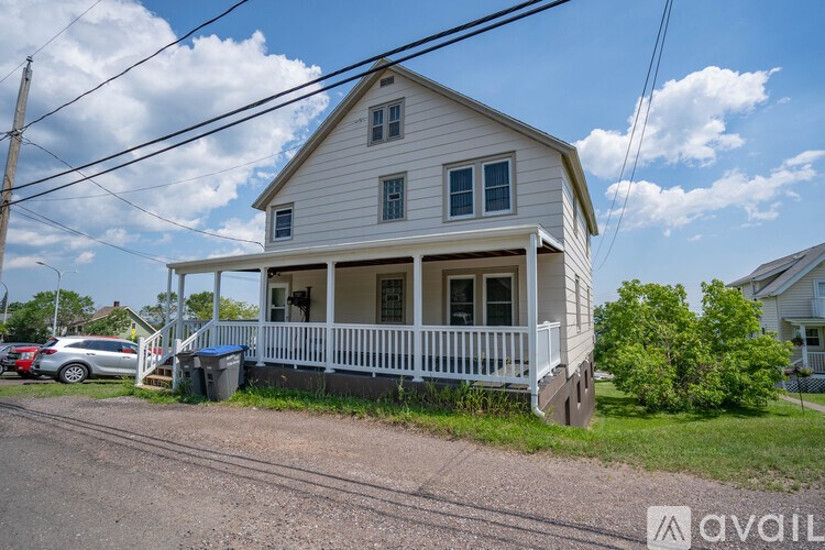 A two-story house with a white exterior and a porch.