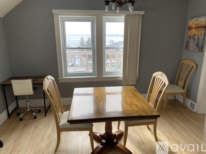 A dining room with a wooden table and chairs.