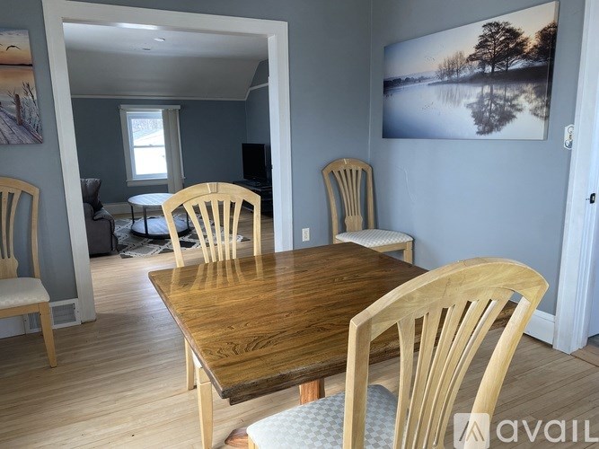 A dining room with a wooden table and chairs.