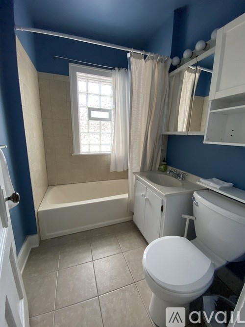 A white toilet sits in a bathroom with blue walls.