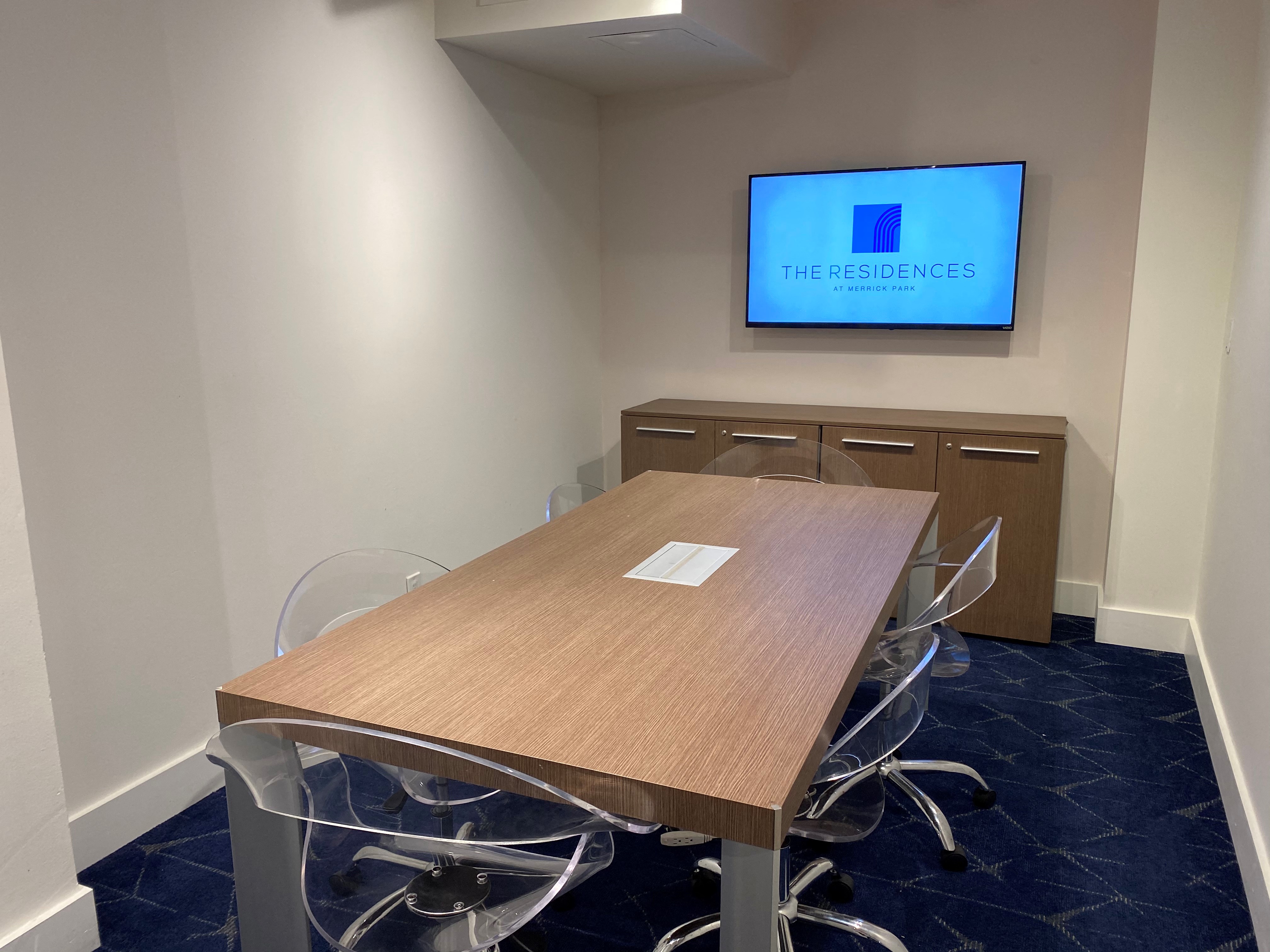 a conference room with a table and a tv