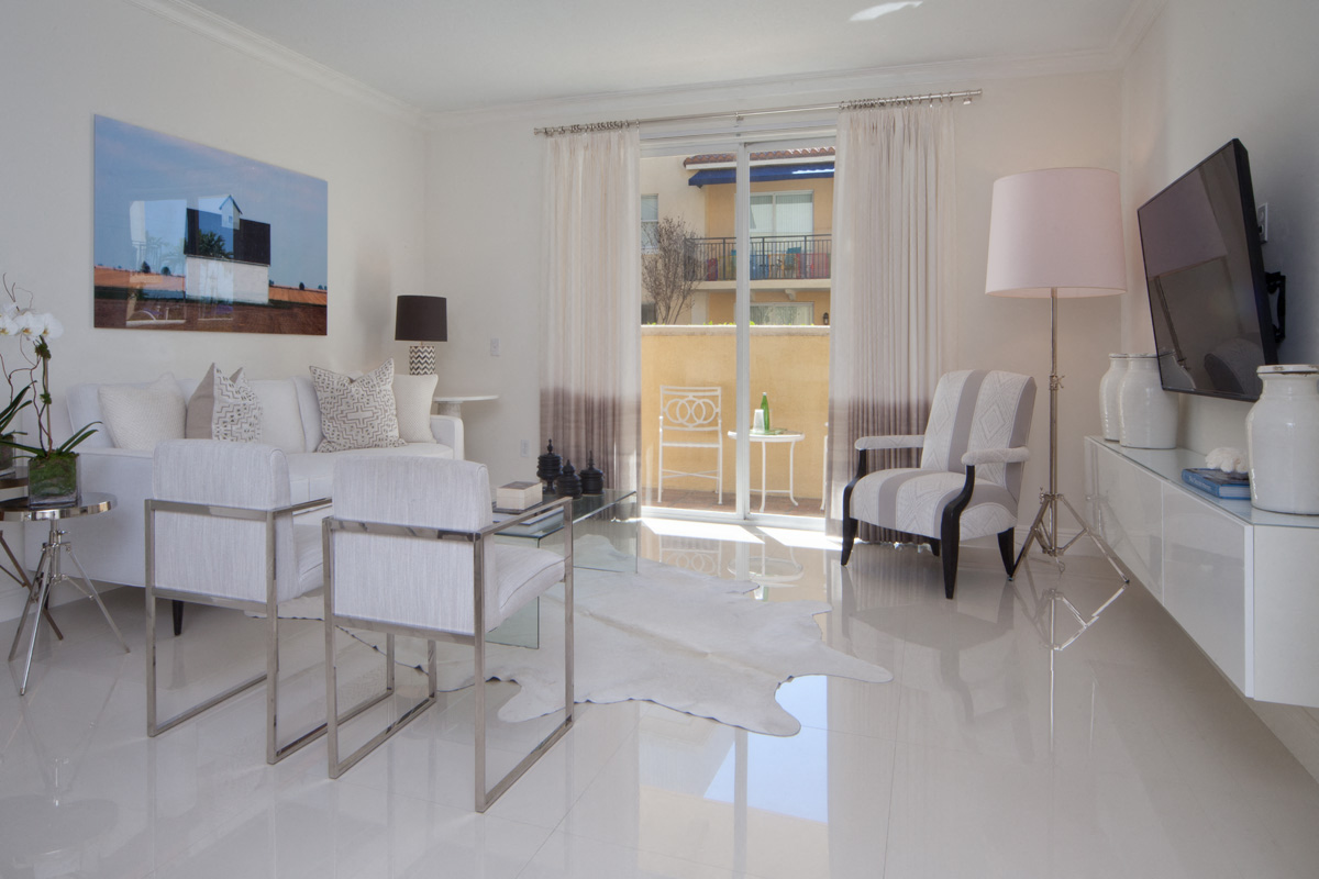 a white living room with a white tiled floor and white furniture