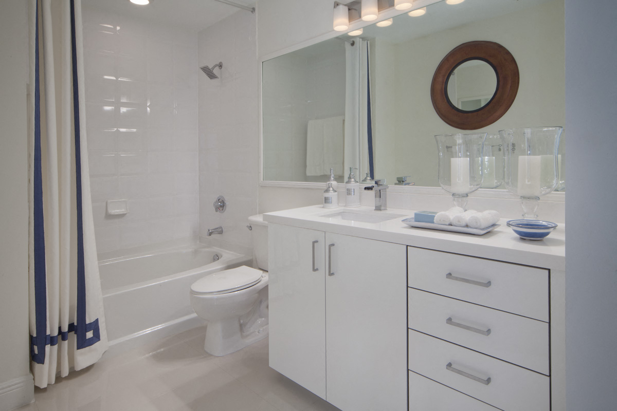 a white bathroom with a shower and a sink and a toilet