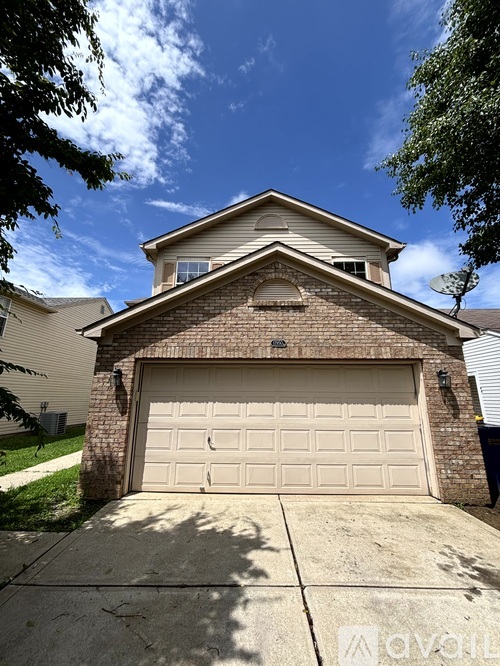 A house with a garage door in front of it.