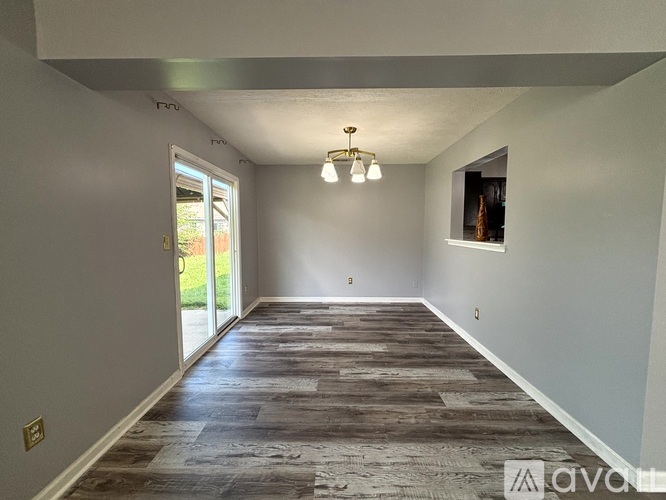 A room with wooden flooring and a chandelier.