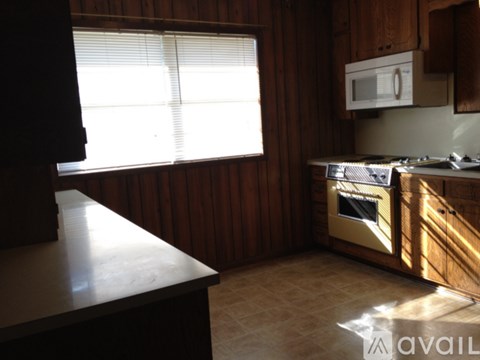 A kitchen with wooden cabinets and a microwave above the stove.