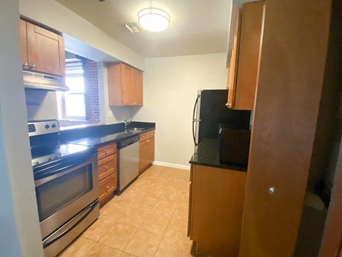 a kitchen with wooden cabinets and a stainless steel stove and refrigerator