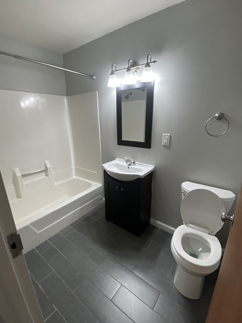 a bathroom with a toilet and a sink and a bath tub