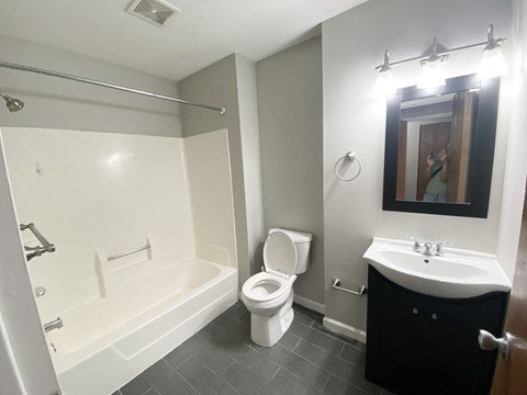 a bathroom with a toilet and a tub and a sink