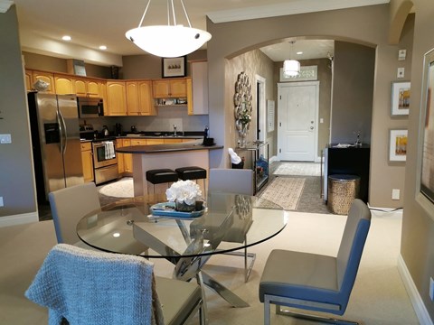 A modern kitchen with a glass table and chairs.