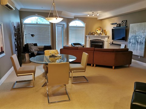 A living room with a glass table and chairs.