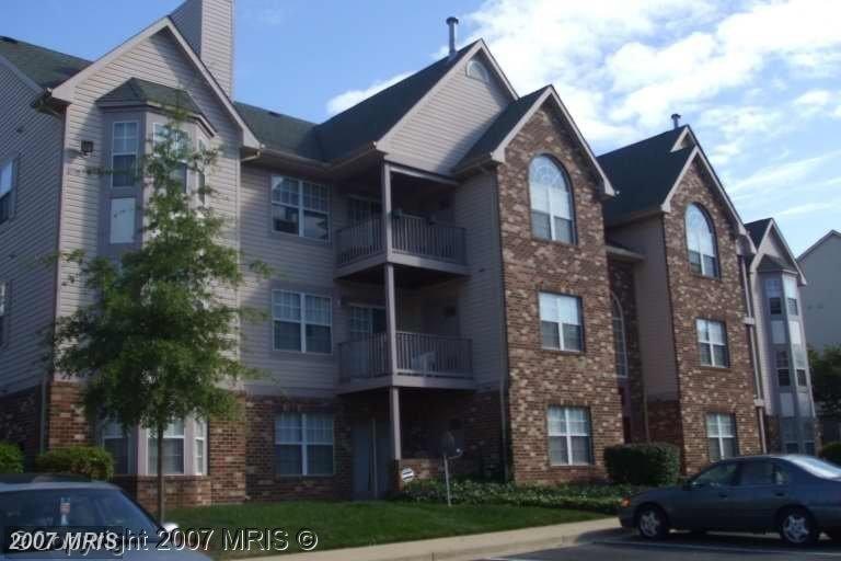 Apartment building with a car parked in front.