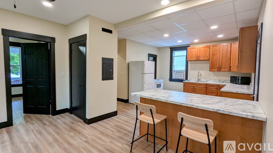 A kitchen area with a bar stool and a counter.