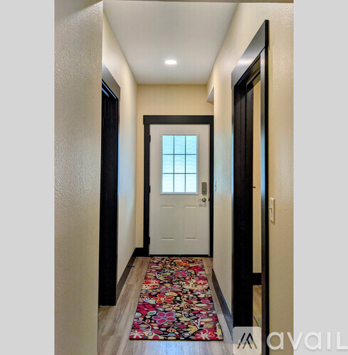 A hallway with a rug and a door.